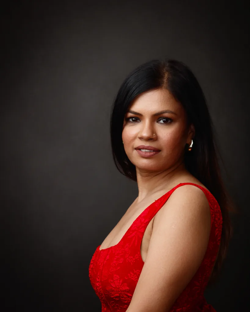 Woman in red dress against dark background.