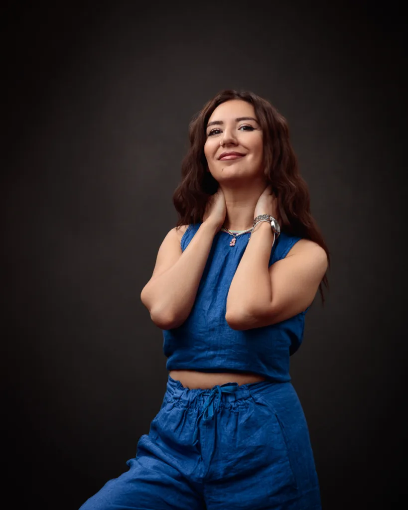 Woman in blue outfit posing confidently.
