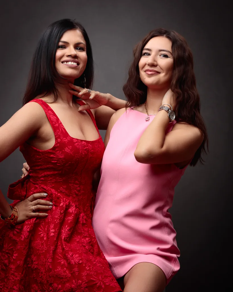 Two women in colourful dresses smiling.