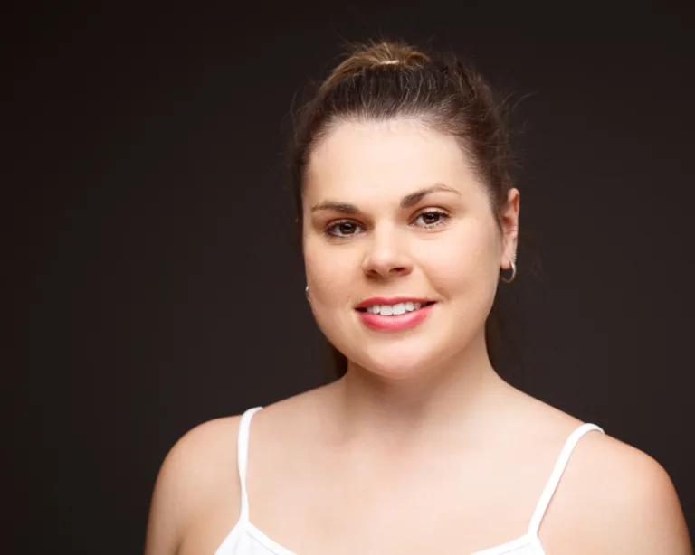Woman smiling against dark background