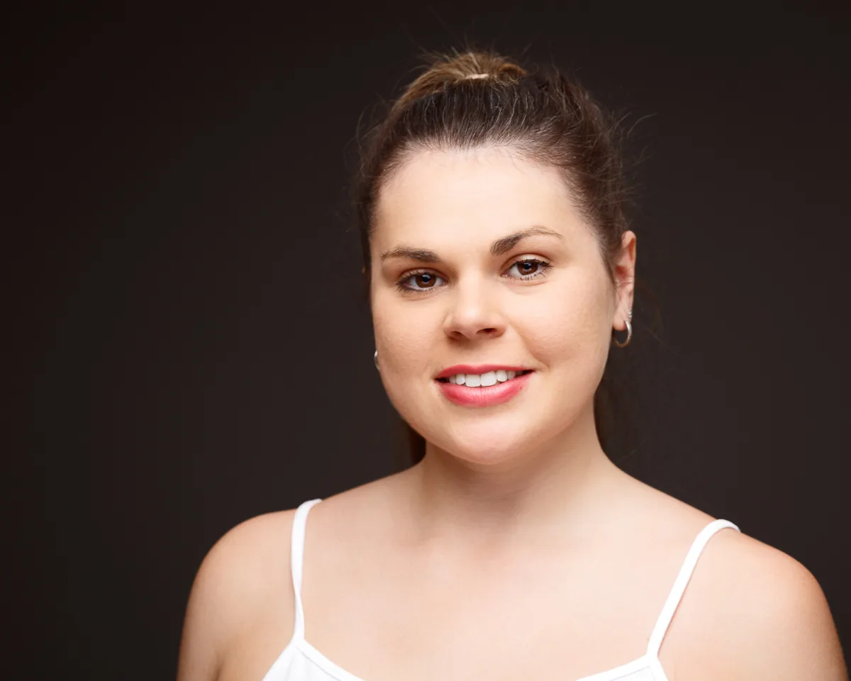 Woman smiling against dark background