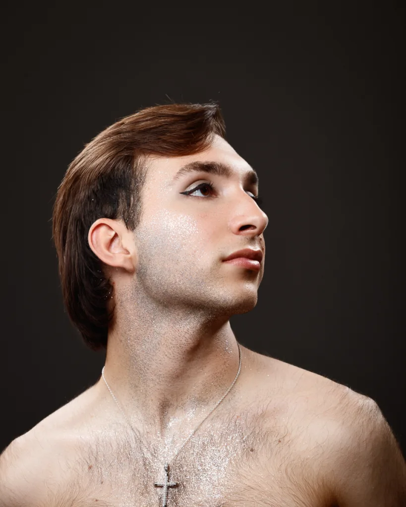 Person with glitter and cross necklace portrait.