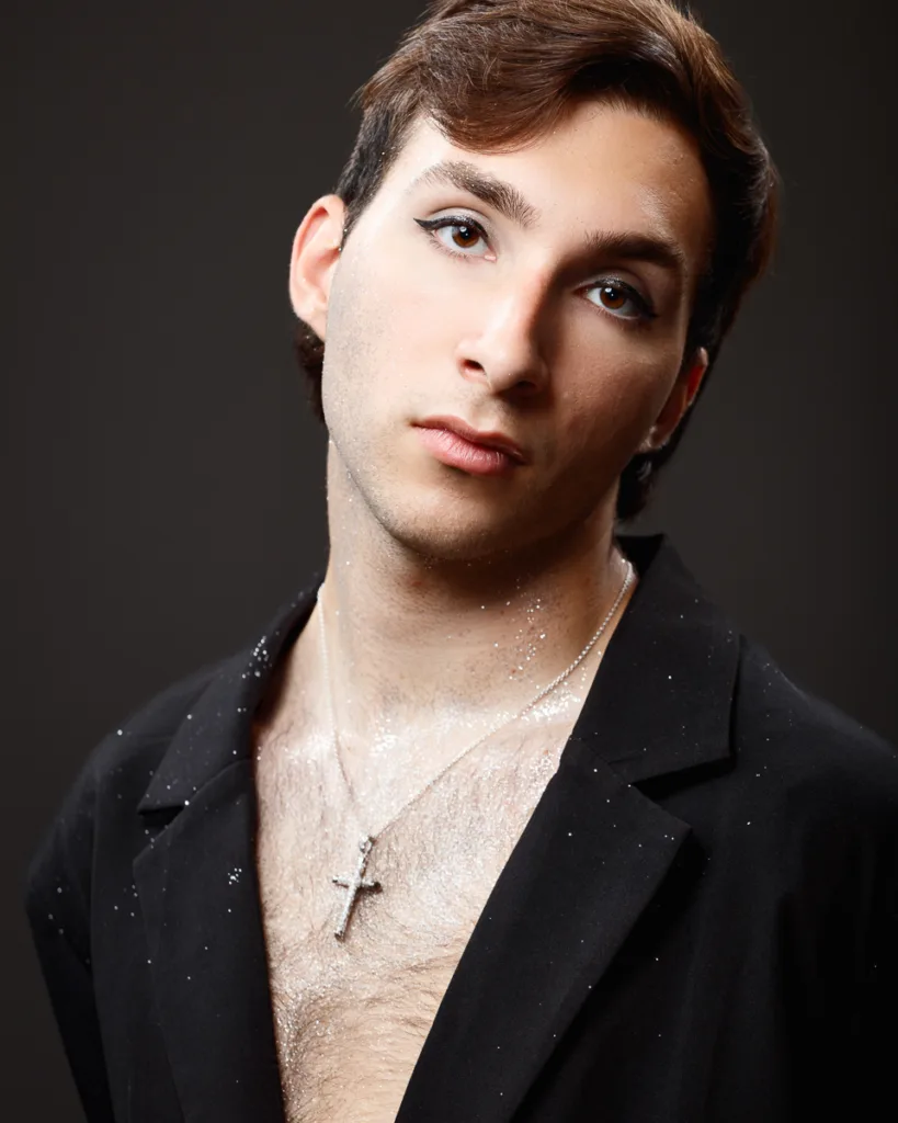 Person wearing makeup and black jacket with glitter.