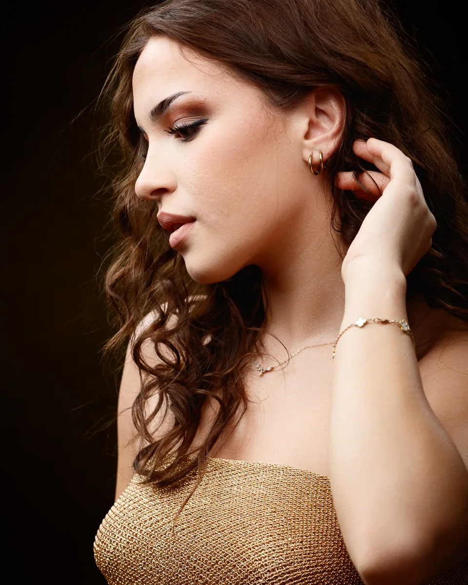 Woman in gold top with curled hair