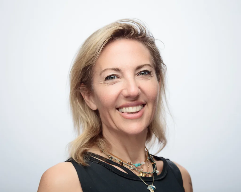 Smiling woman with necklace, light background
