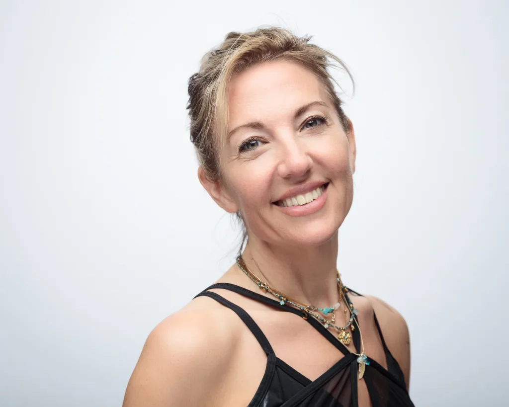Smiling woman in black dress, white background