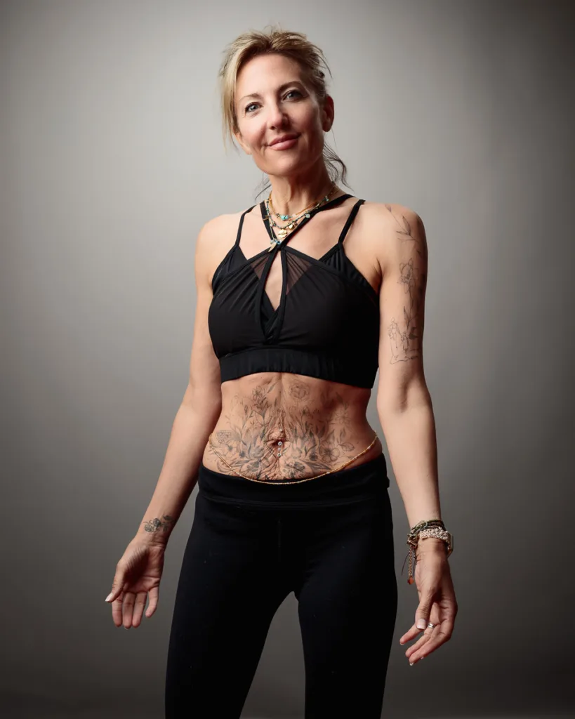 Woman with tattoos in black sportswear smiling