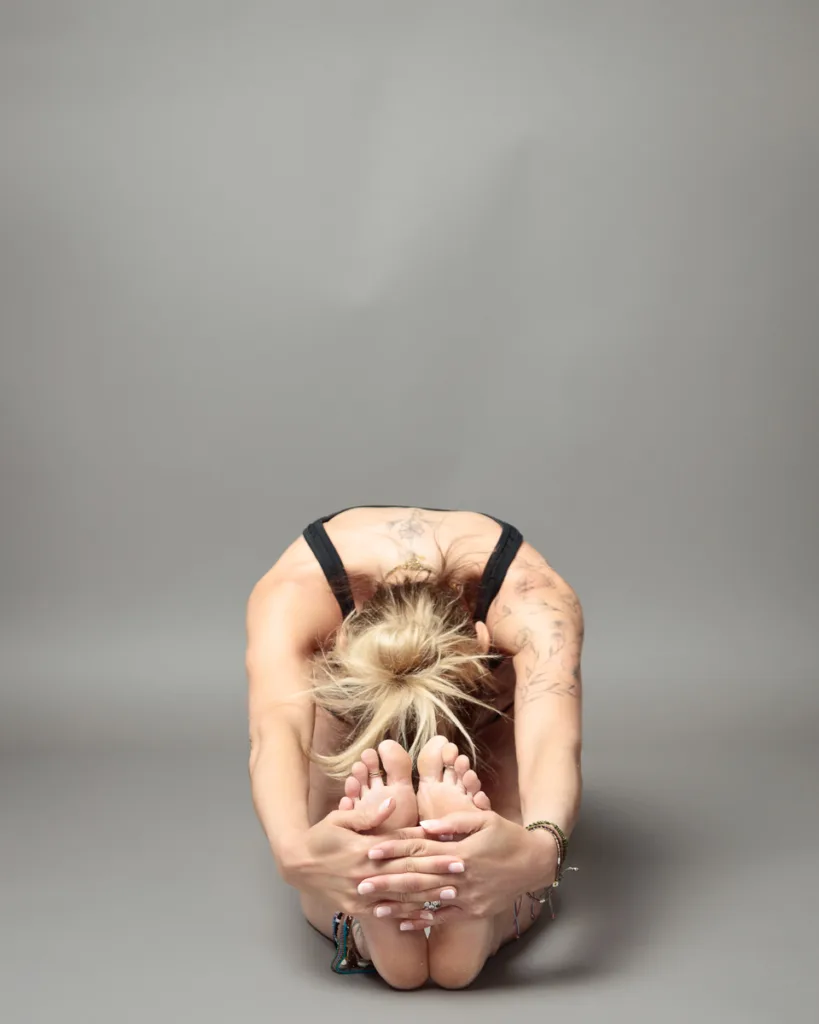 Person performing seated forward bend yoga pose