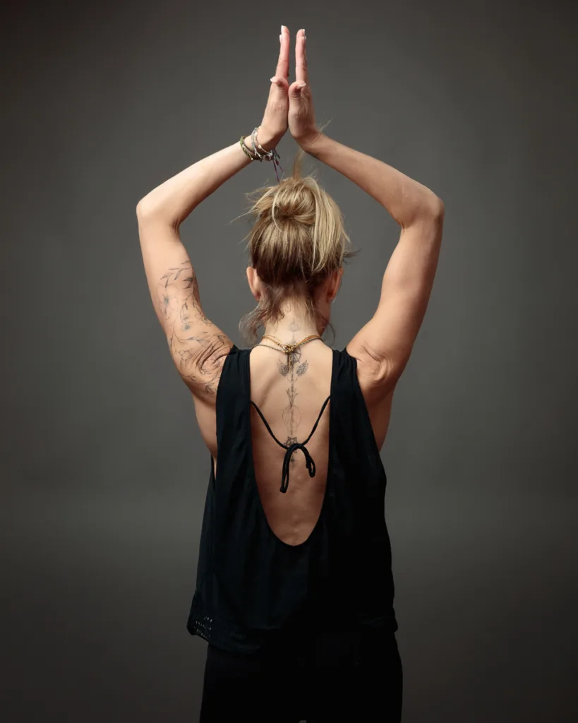 Woman with tattoos practicing yoga pose gracefully.