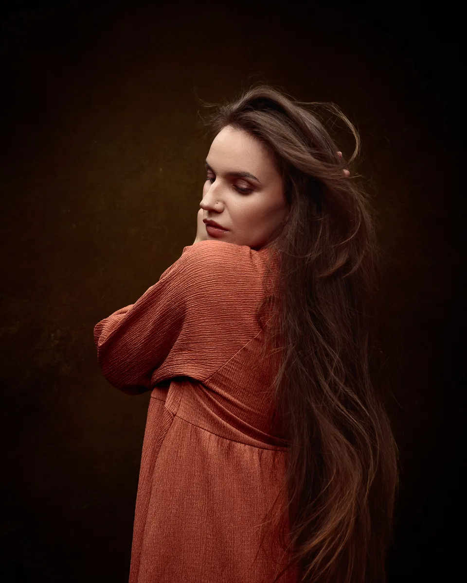 Woman in orange dress with long flowing hair.