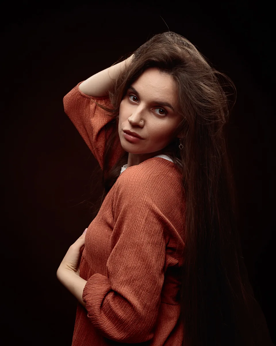 Woman in orange top with long brown hair