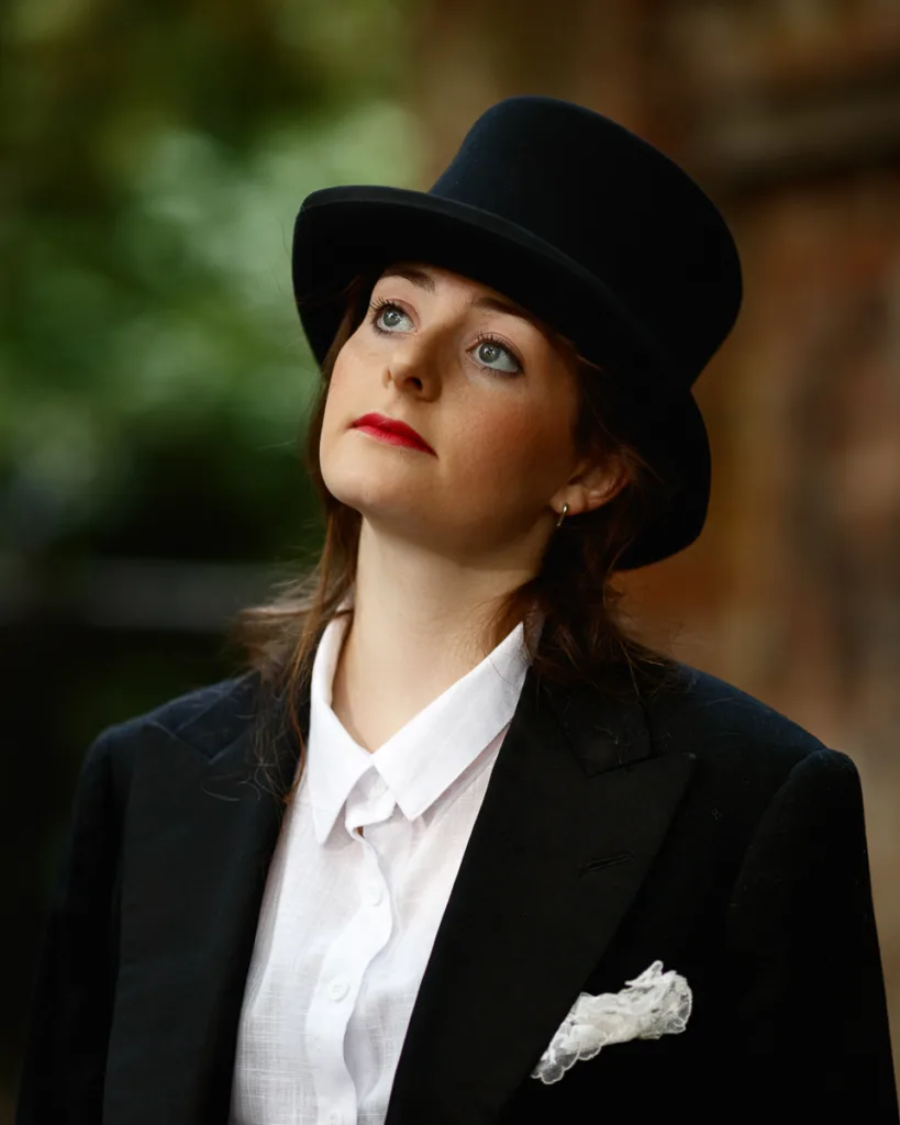 Person in formal attire with a top hat.