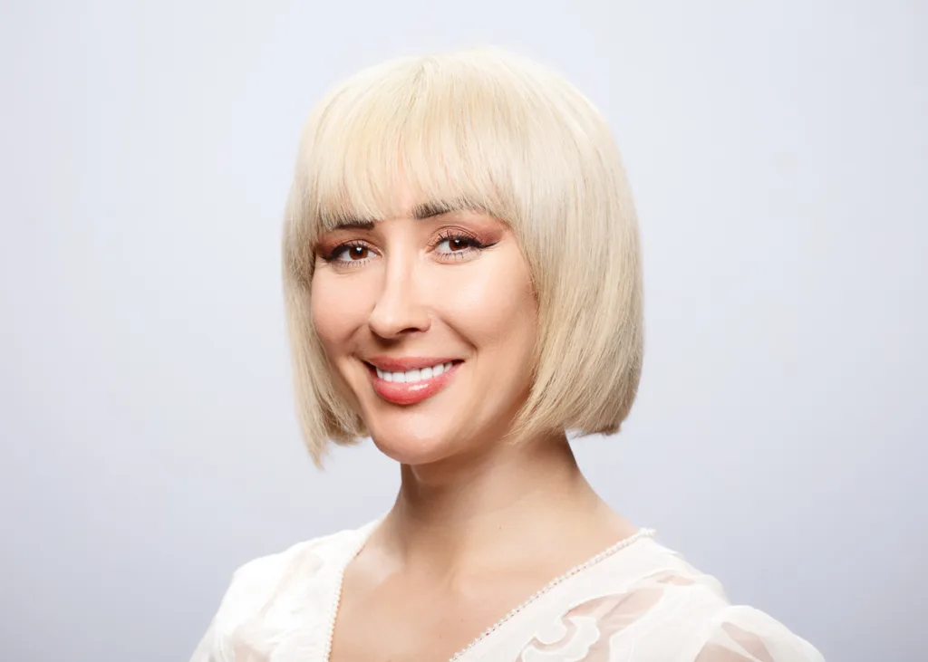 Smiling person with blonde bob hairstyle