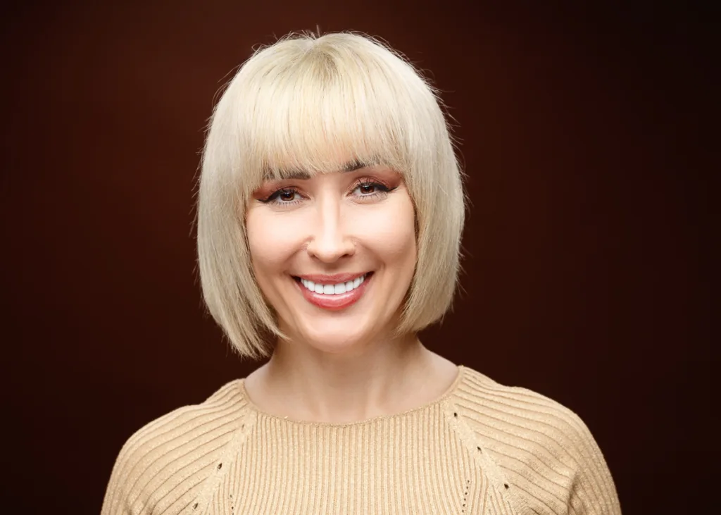 Smiling woman with blonde bob haircut