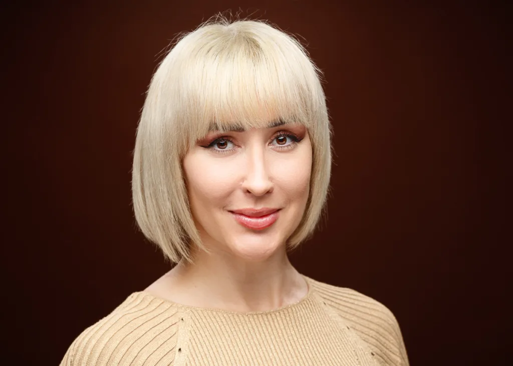 Woman with short blonde hair smiling.