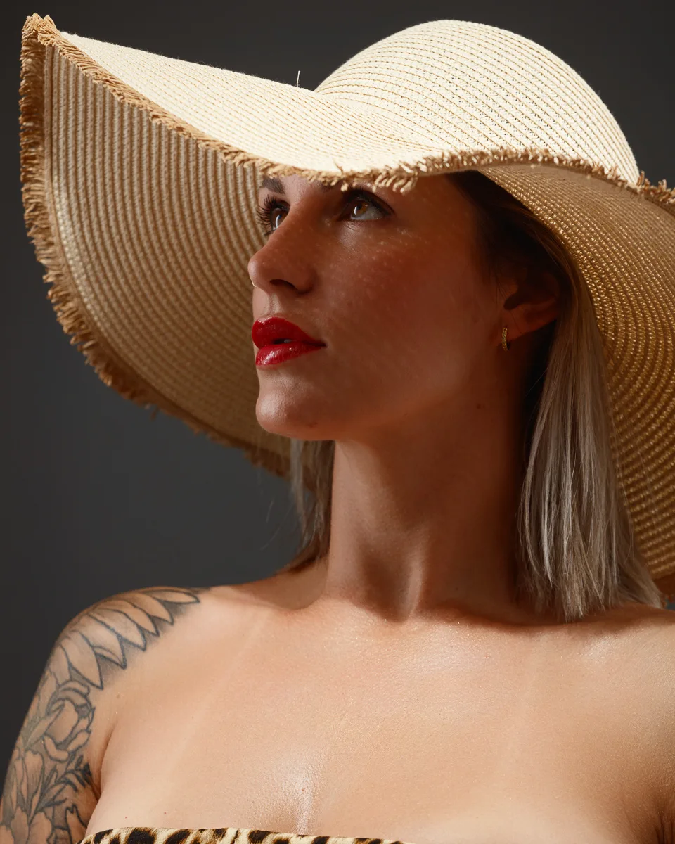Woman with wide-brim hat and tattoos.