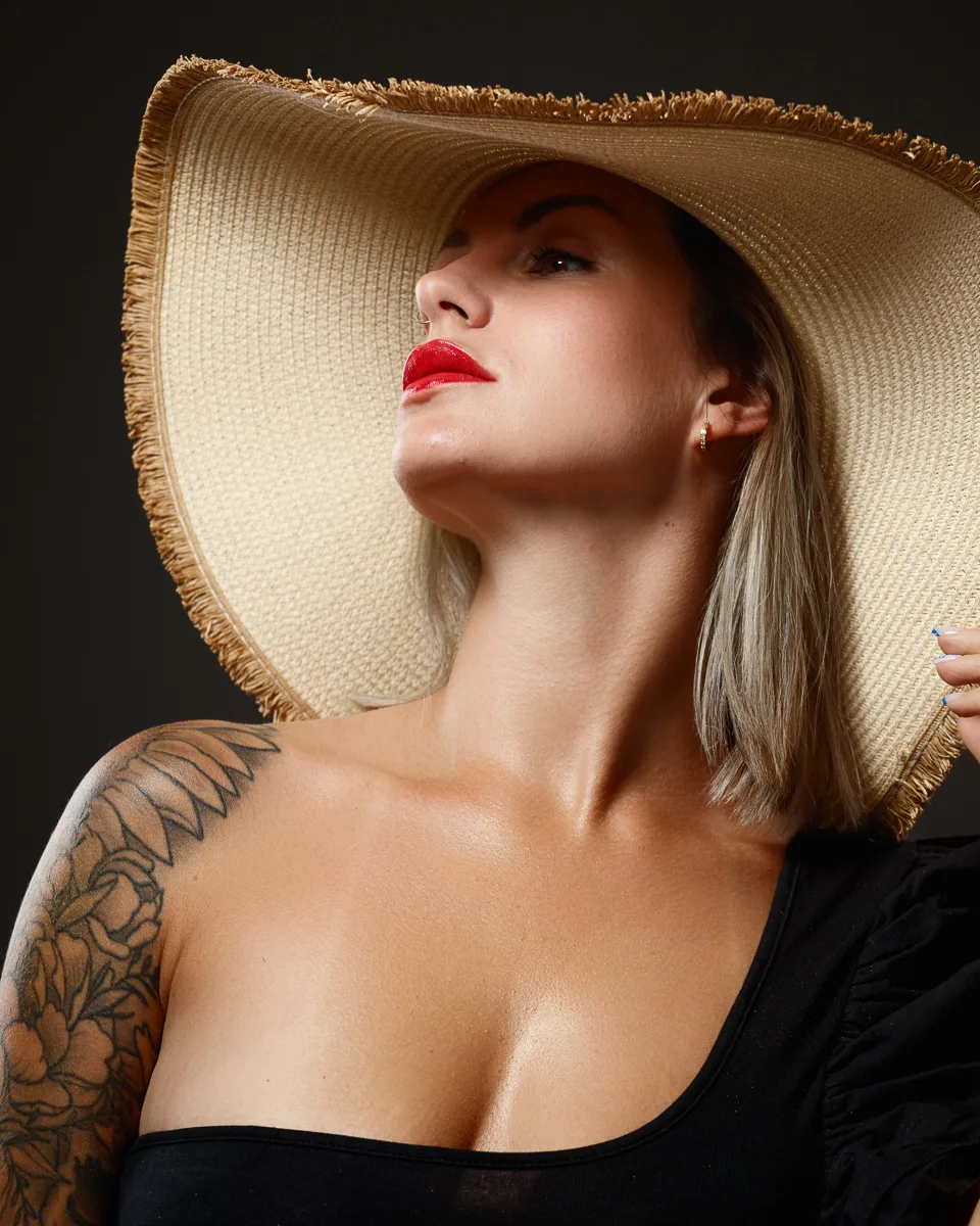 Woman in sun hat with tattooed shoulder