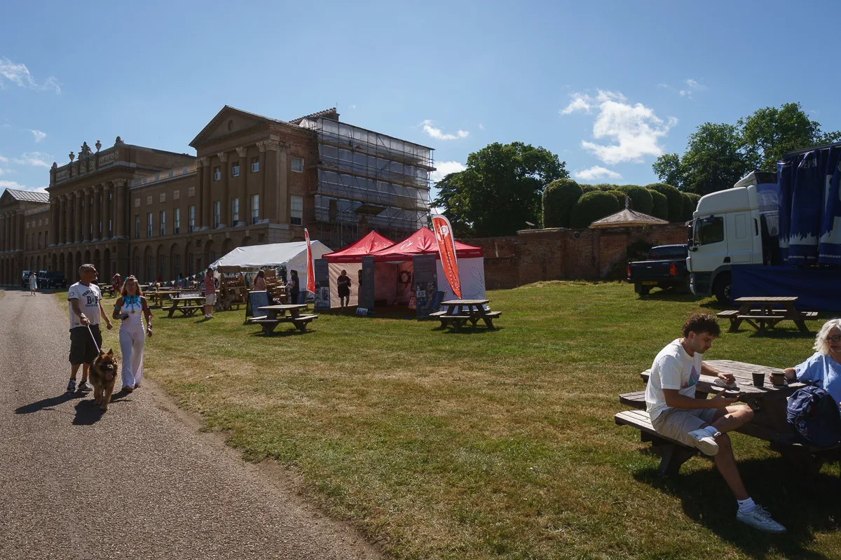 People at outdoor event near large historic building.