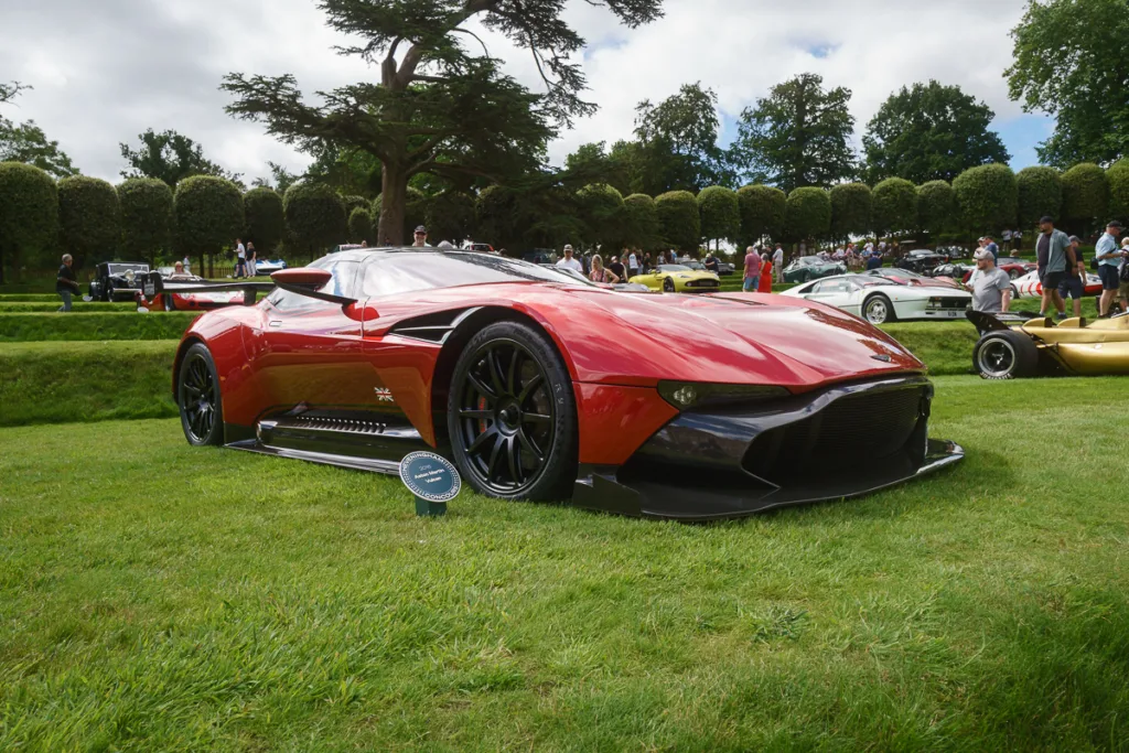 Red sports car displayed at outdoor car show.