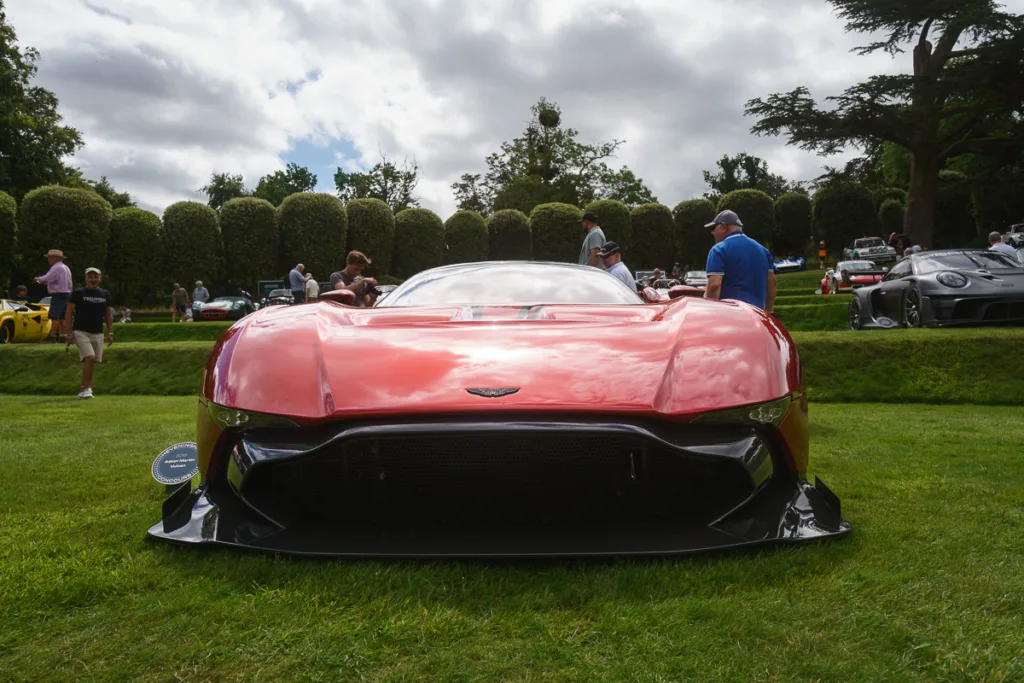 Red sports car on display at outdoor event.