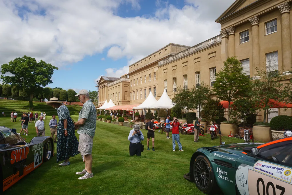Vintage cars displayed outside historic mansion.