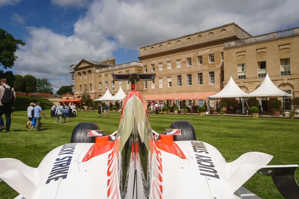 Race car displayed in front of a historic building.