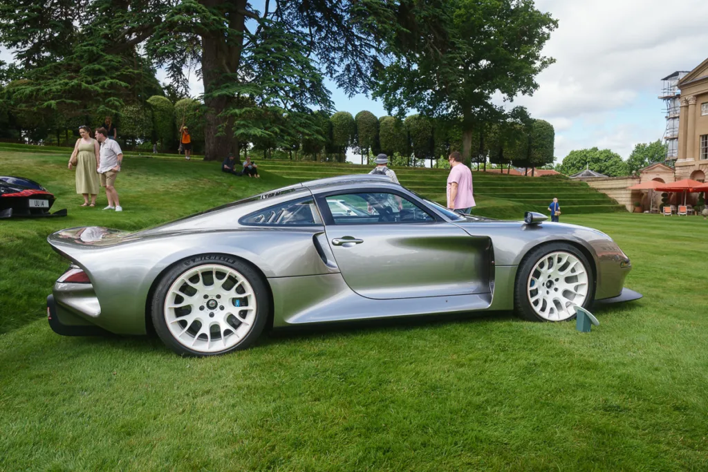 Silver sports car displayed on green lawn.