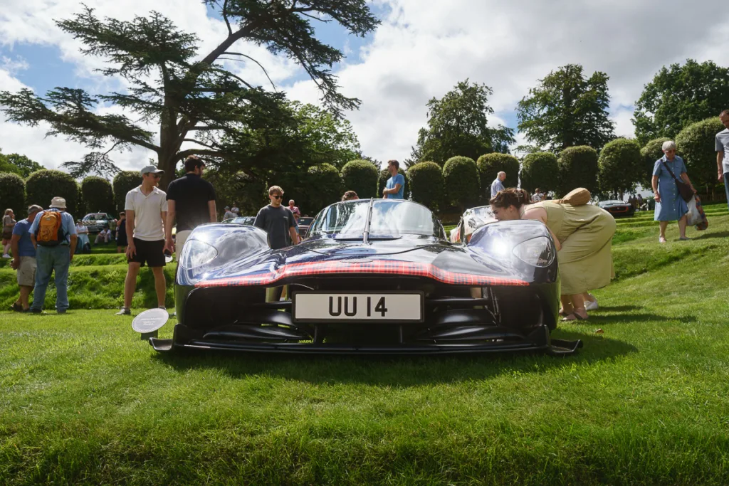 Black sports car on display at outdoor event.