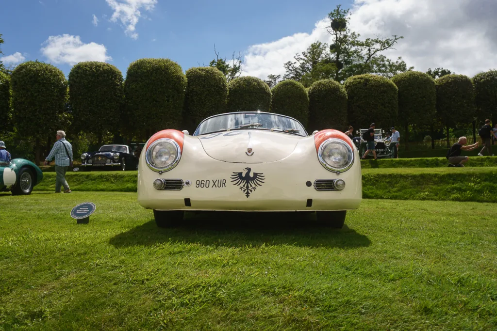 Classic white sports car at outdoor car show.