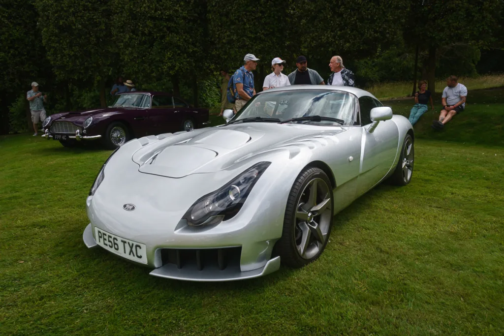 Silver sports car displayed at outdoor event.