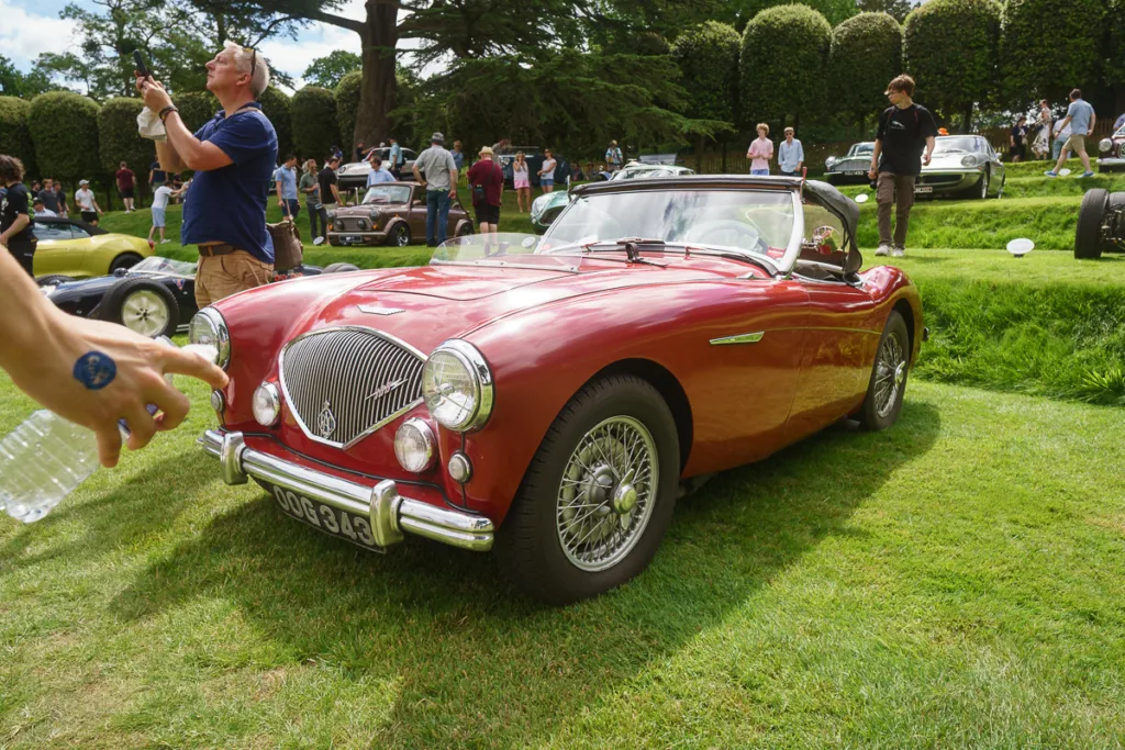 Classic red convertible on display at car show.