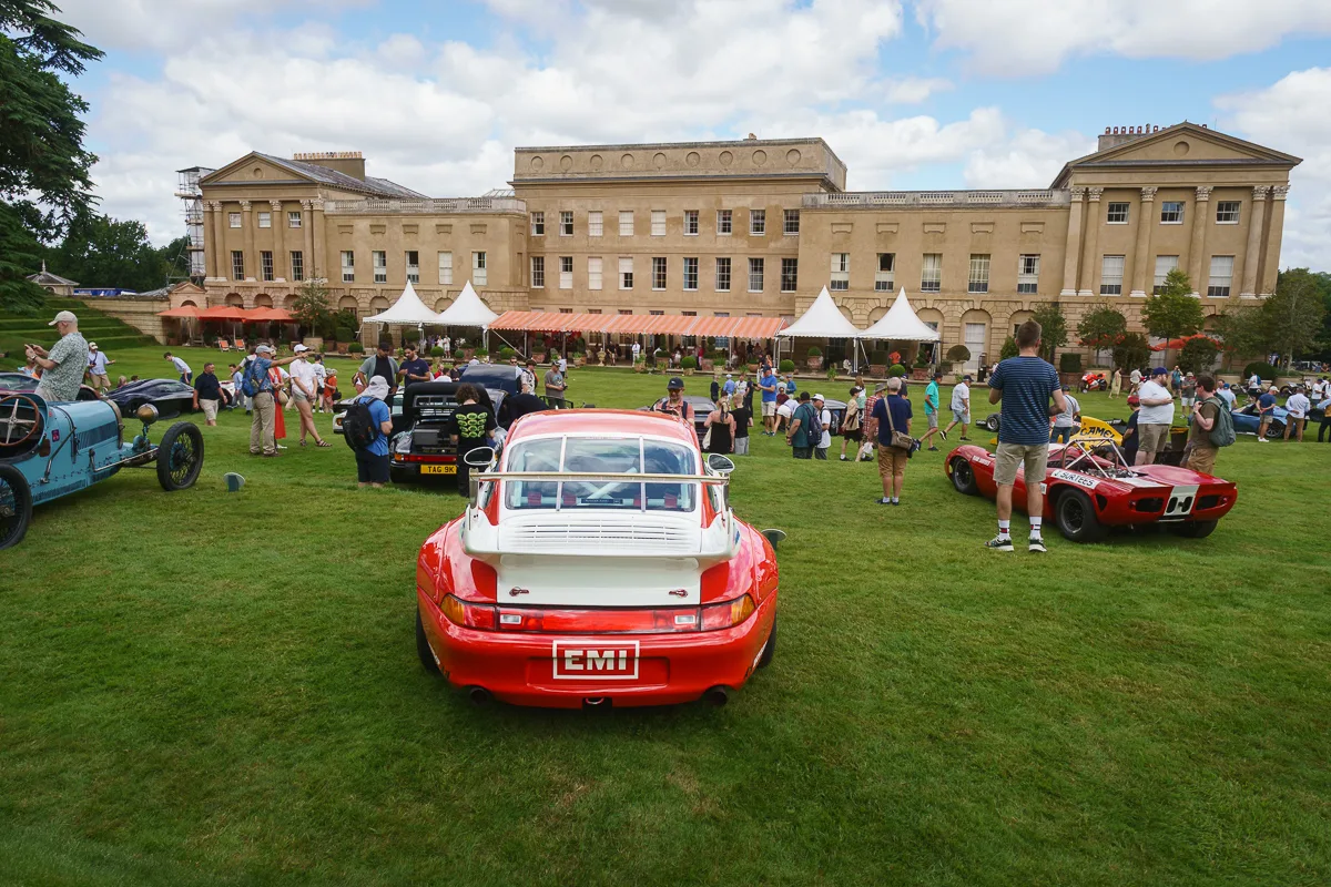 Classic cars displayed outside historical building event.