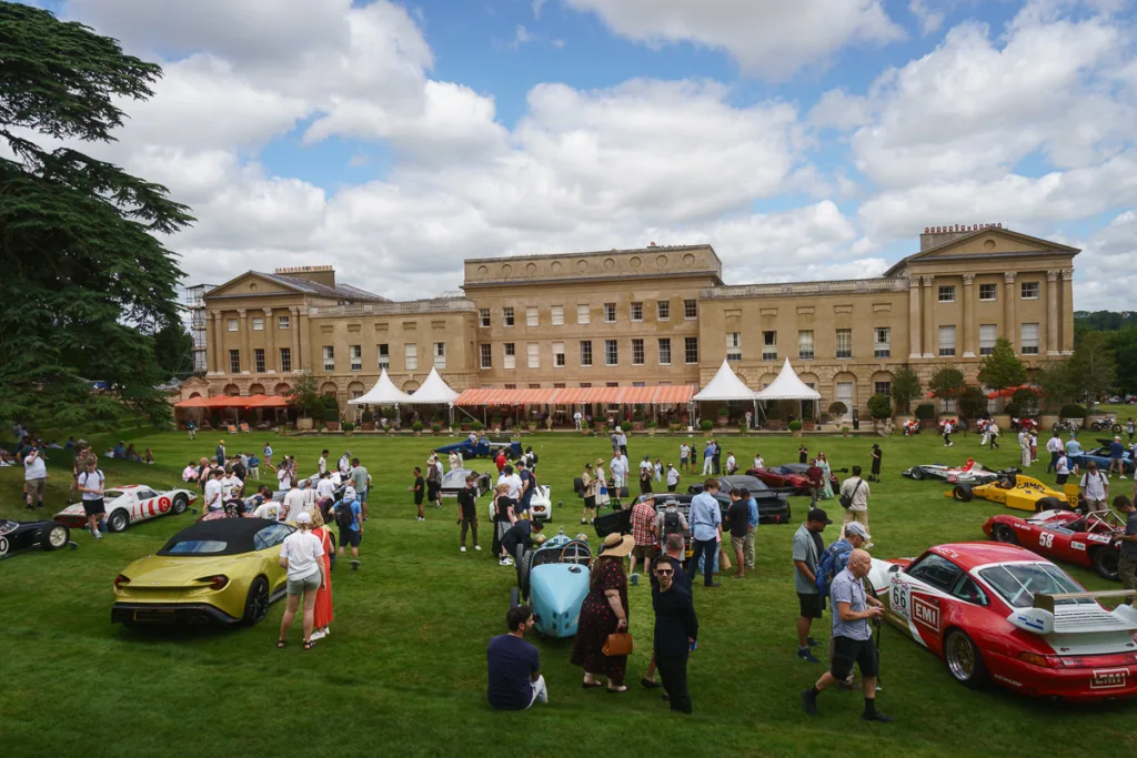 Classic car show in front of grand historic building.