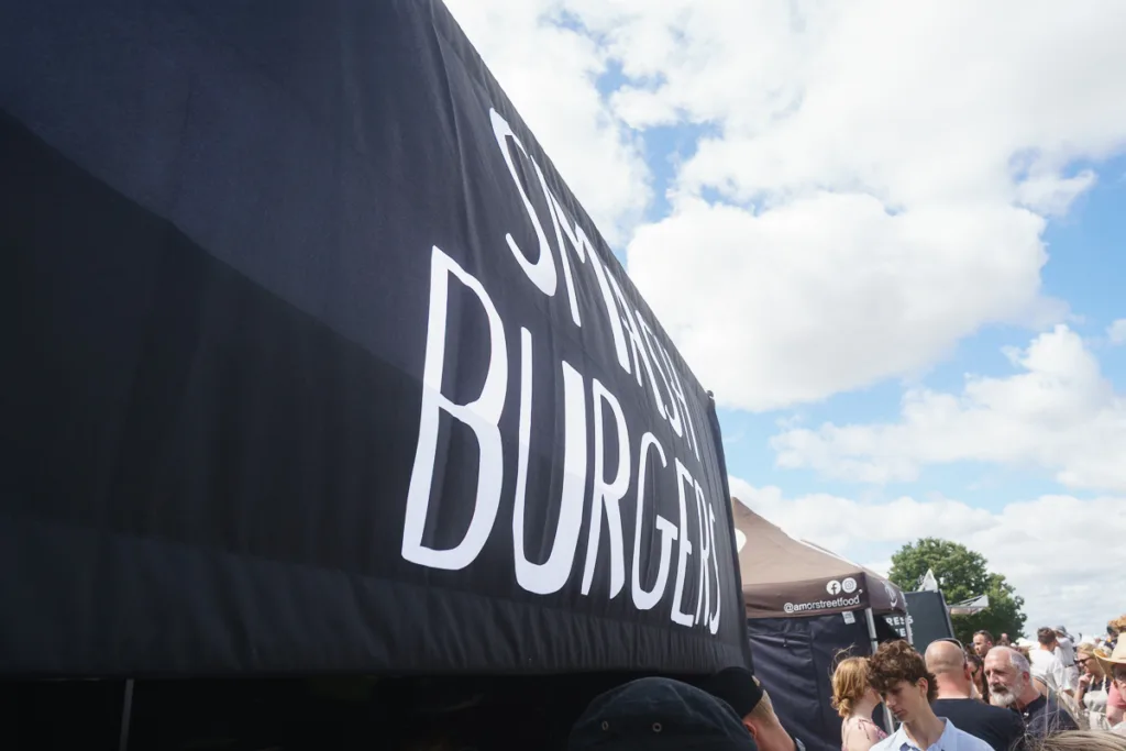 Smash Burgers stand at outdoor festival crowd scene.
