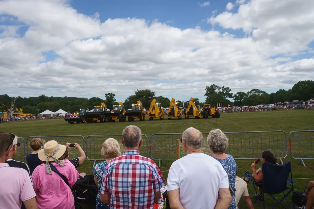 Crowd watching digger show on sunny day