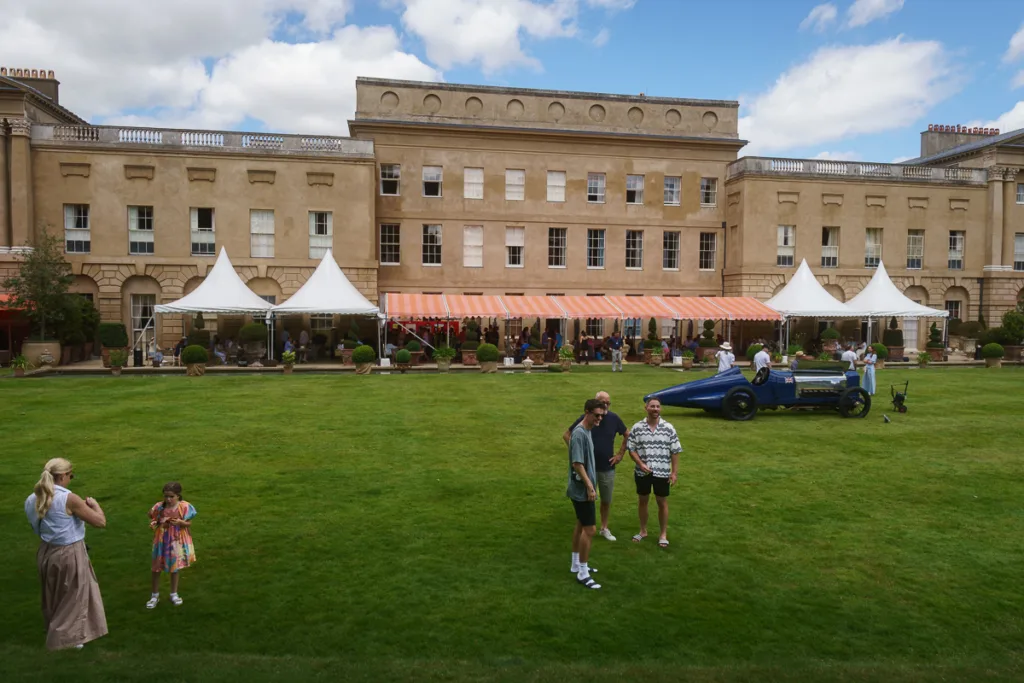 Historic mansion garden event with classic car display.