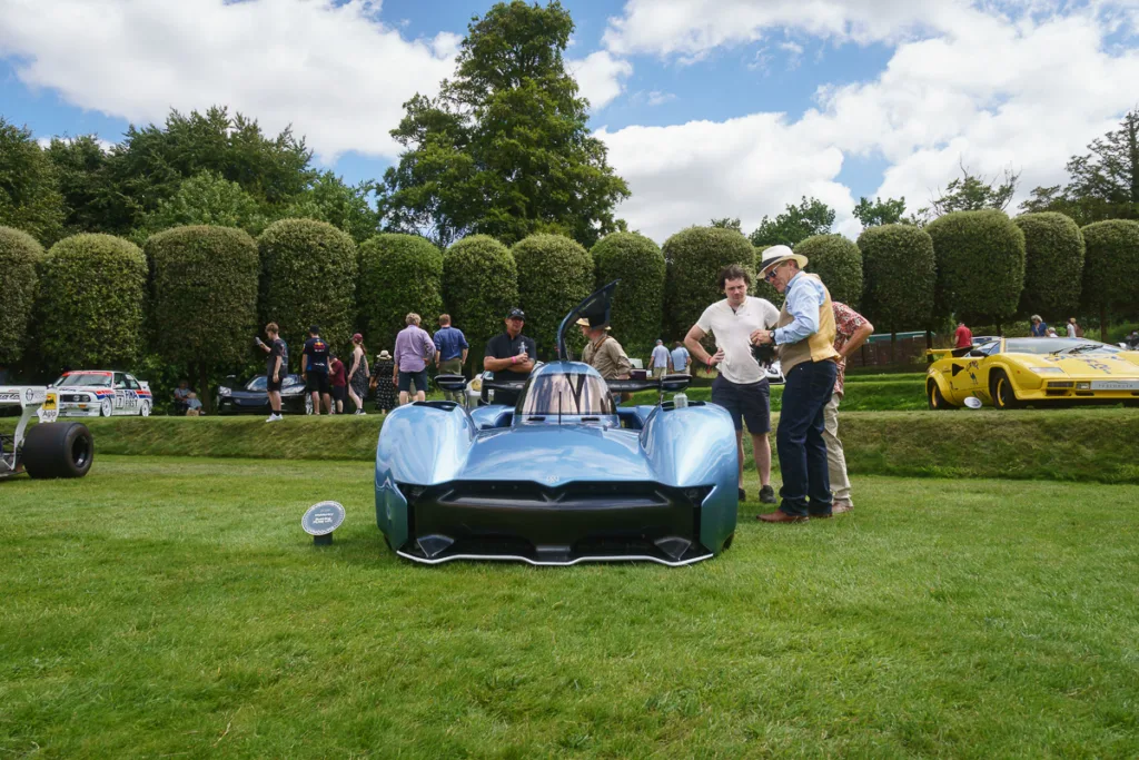 Futuristic blue race car at an outdoor event.