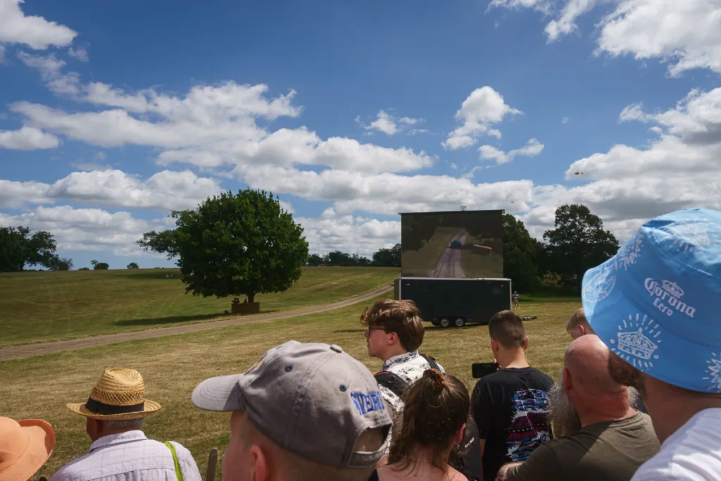 People watching outdoor screen at countryside event