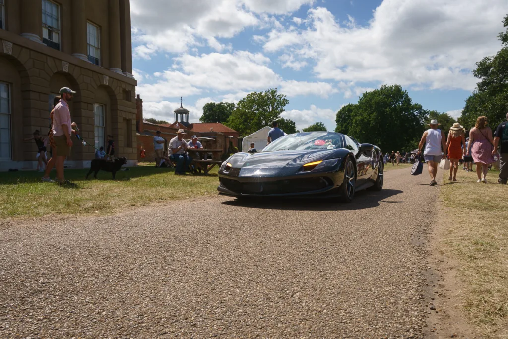 Luxury sports car on country estate driveway.