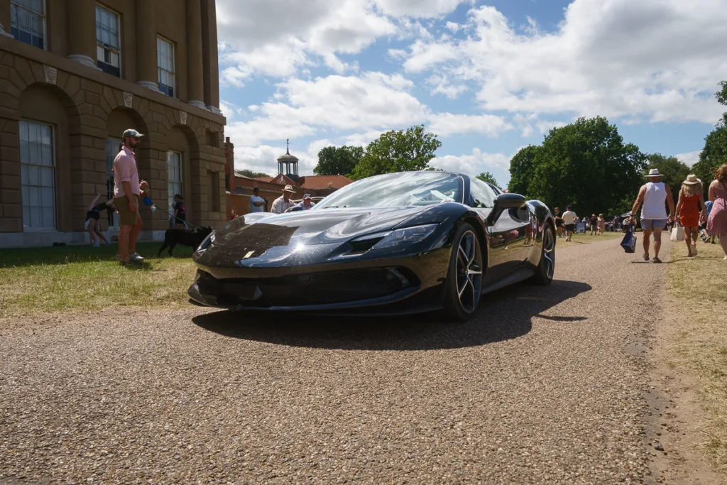 Black sports car on sunny day at outdoor event.