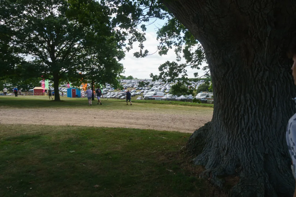 People walking near large parking area at festival.
