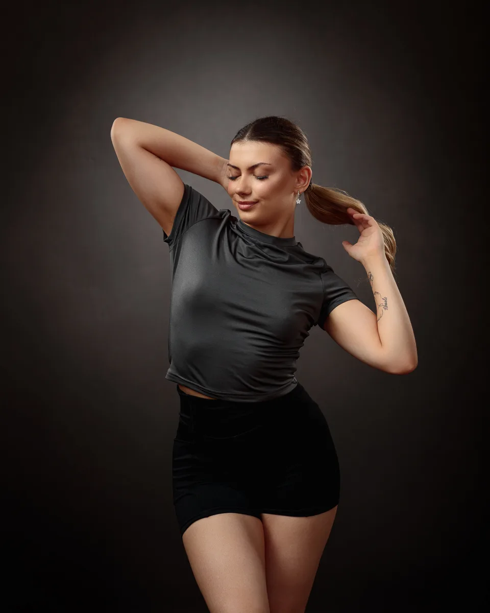 Person posing confidently in dark attire.
