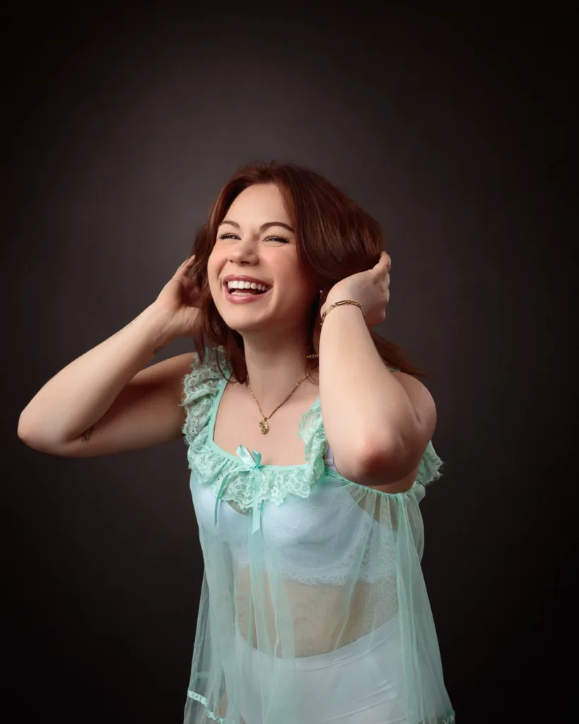 Smiling woman in sheer teal outfit