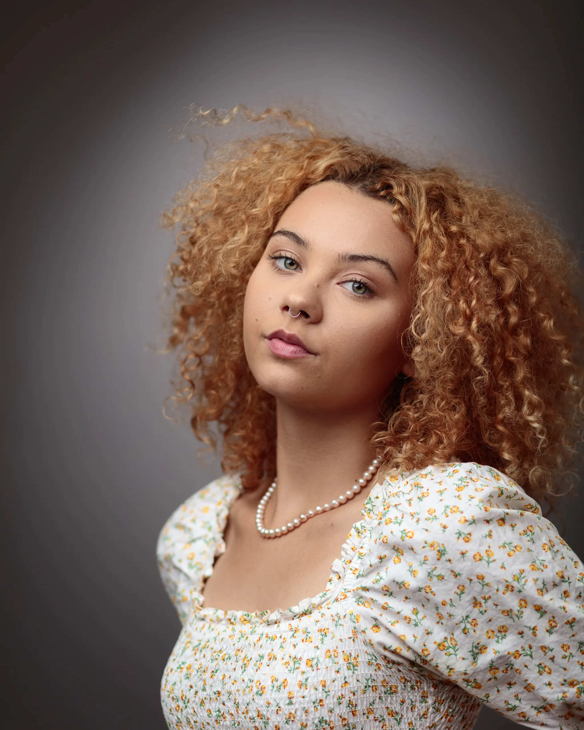 Woman with curly hair wearing floral top