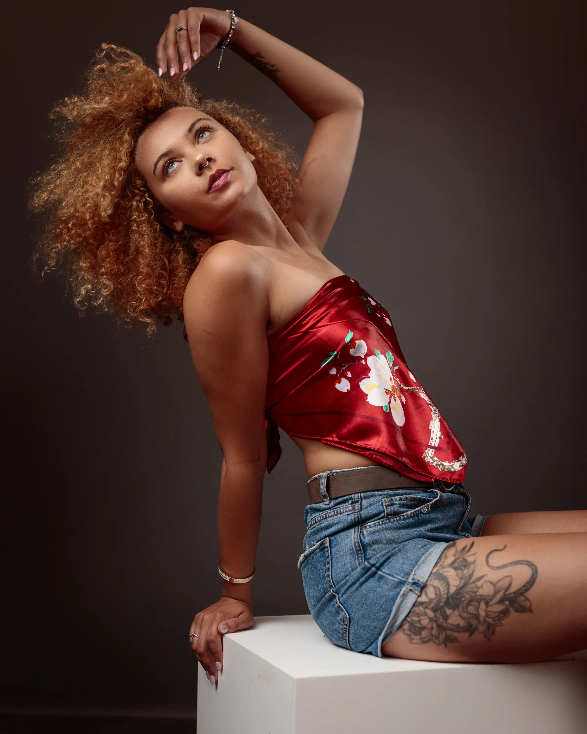 Fashionable woman posing elegantly in studio setting.
