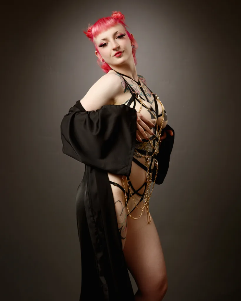 Person in black attire with pink hair