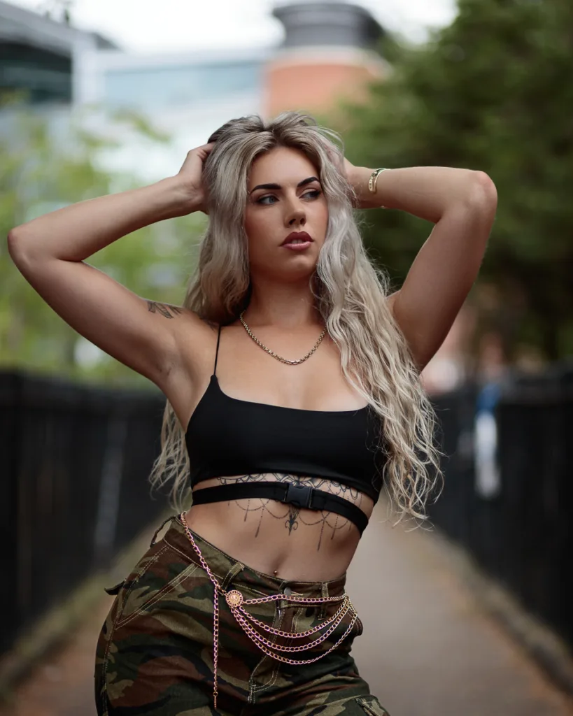 Blonde woman posing in urban setting.