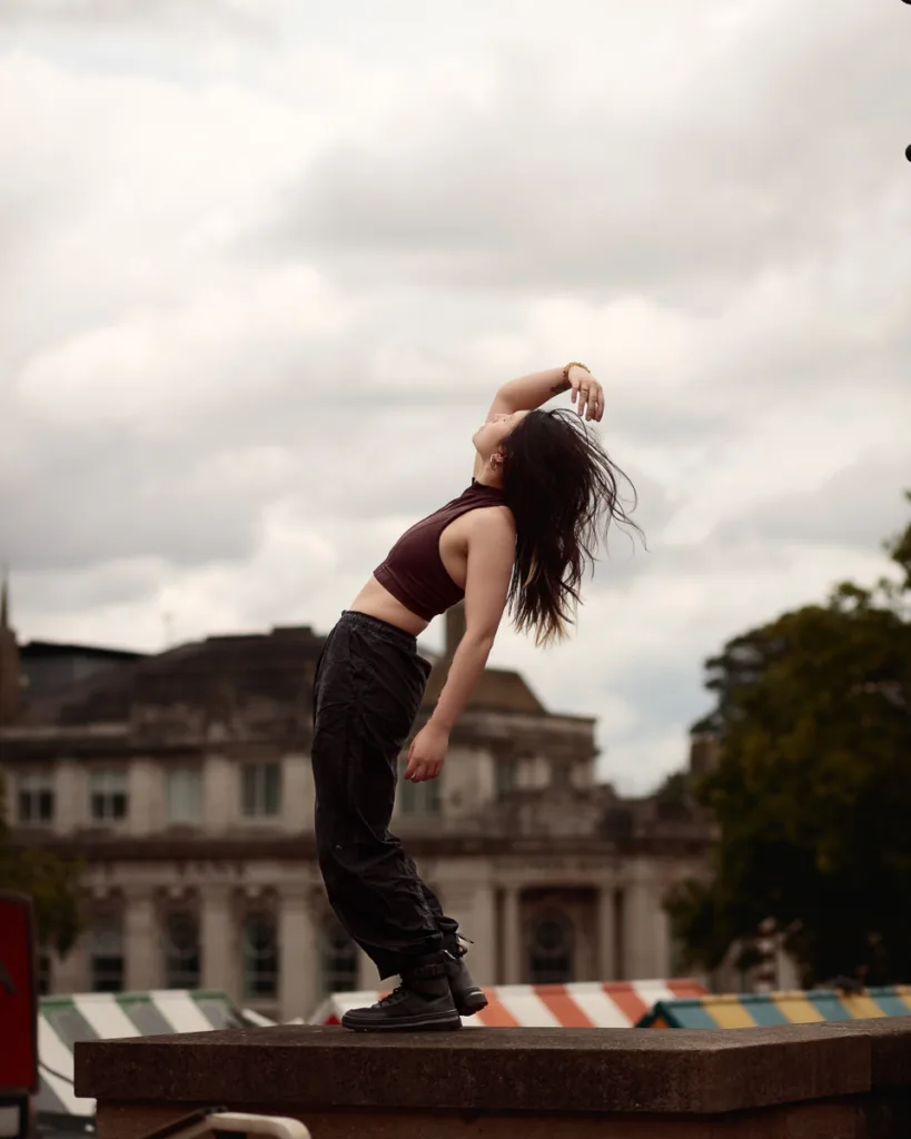 Person dancing on rooftop with cloudy sky