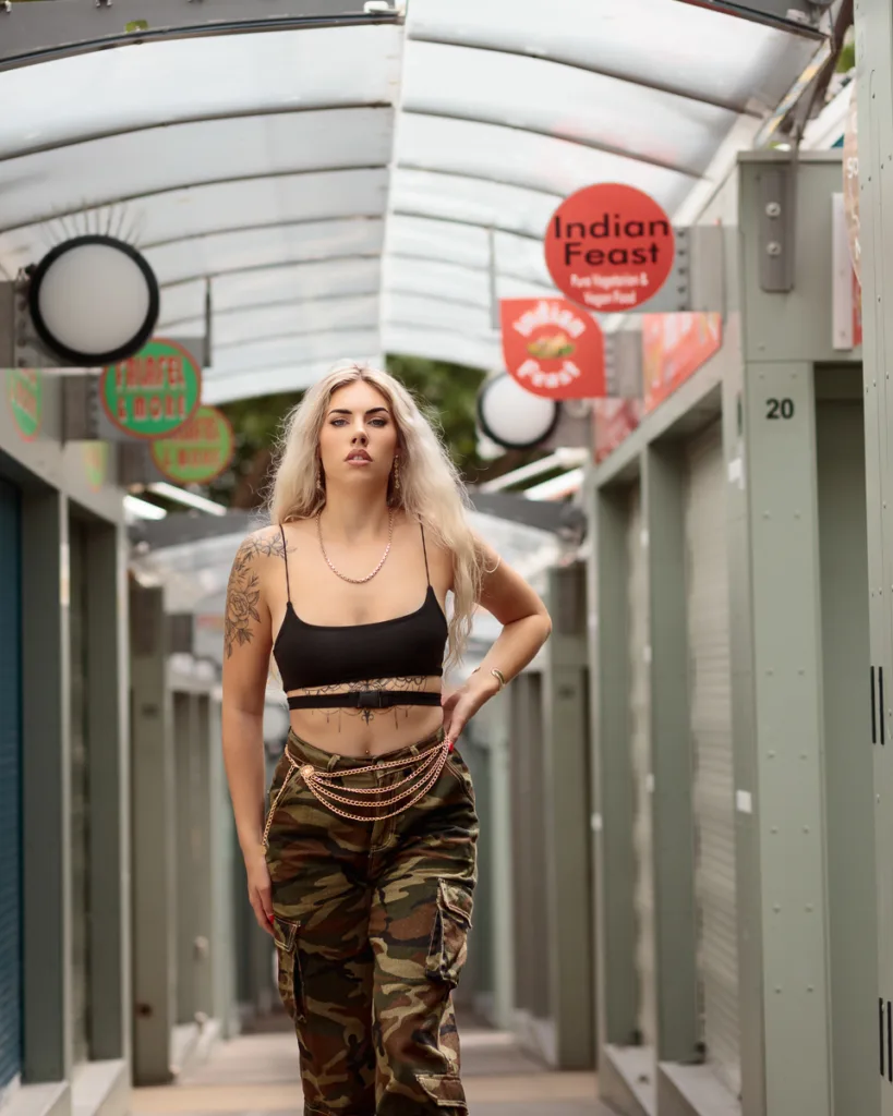Woman in urban outfit walking through market area.