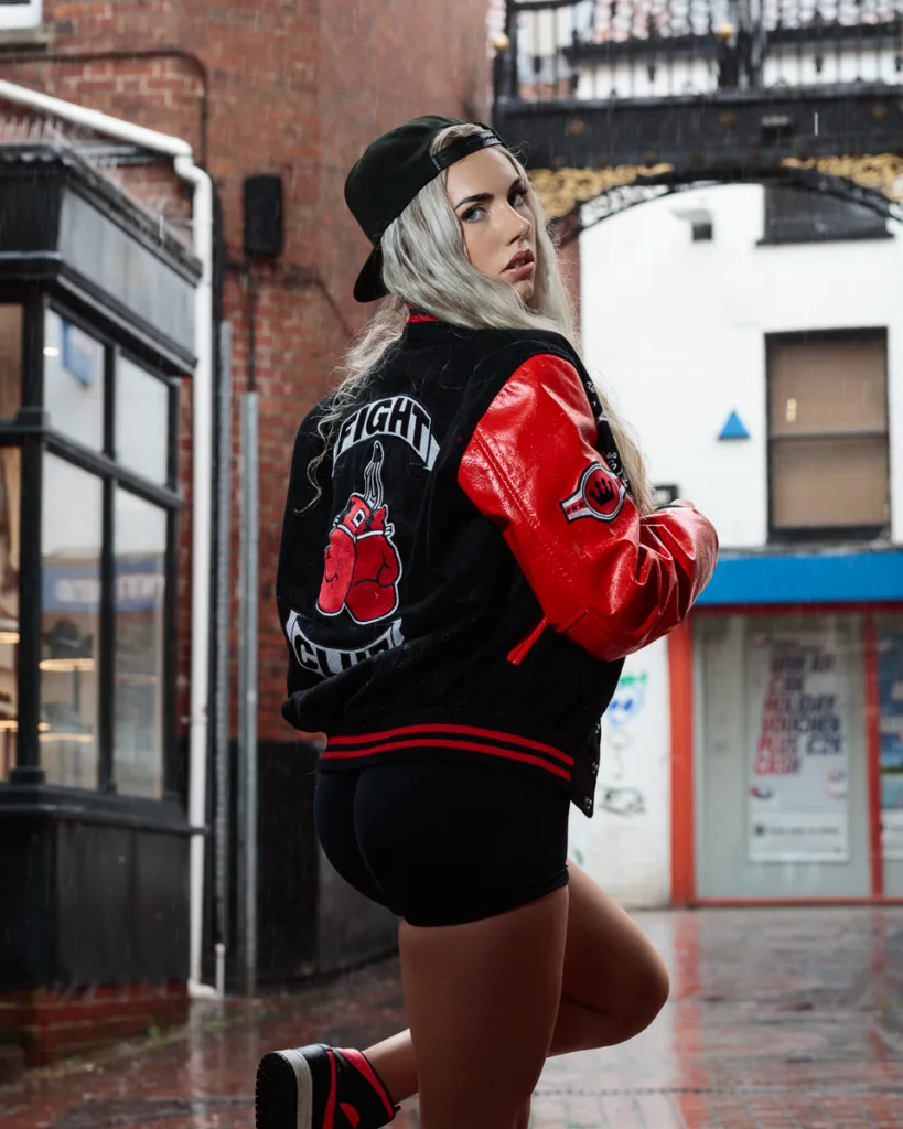 Person in urban street wearing red and black jacket.
